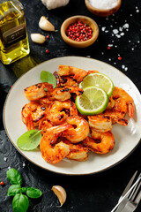 Grilled tiger shrimps with spice and lime. Black background. 