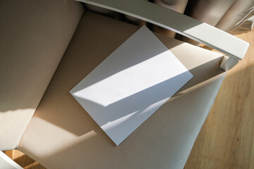 blank paper mockup on elegant soft armchair , shadow overlay, morning light