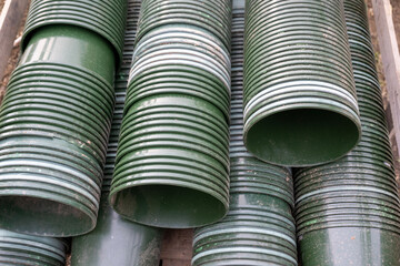 A large number of green plastic plant pots stacked


