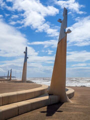 Seafront at Thornton Cleveleys showing the modern curved sea defenses with steps and breaking waves on the beach