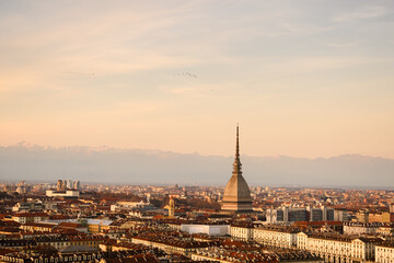 Panoramic view of the city of Turin (Torino) during sunset. Mole Antonelliana and Alps mountains on...