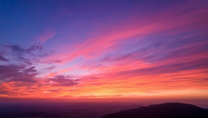 Obraz premium A breathtaking sunset sky transitioning through soft gradient hues of pink, orange, and purple, creating a dreamy and atmospheric scene.