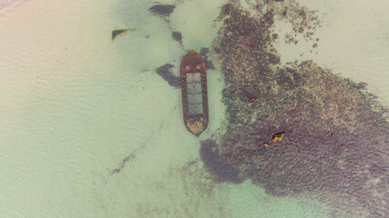 Aerial view of a sunken boat. Sunken ship at shallow depth, near the beach