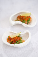 Salmon tartare appetizer with caviar. Mini tartlets with red salmon caviar and smoked salmon, an appetizer idea for a festive table