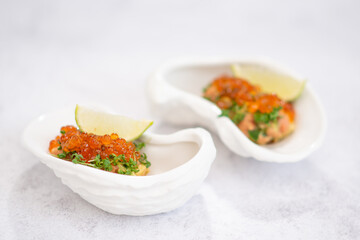 Salmon tartare appetizer with caviar. Mini tartlets with red salmon caviar