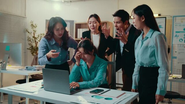 Asian business team blaming upset employee in office