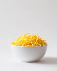 Shredded yellow cheese in a white bowl on a white surface, representing simple ingredients. Ideal for culinary projects, dairy products, and food photography.