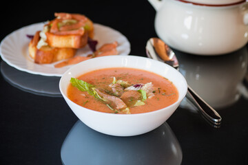 Cream soup of red fish with aromatic spices and herbs, isolated on black background