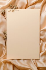 Soft beige fabric drapes elegantly under blank sheet, adorned wi