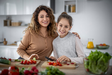 Mom and daughter enjoying cooking together in a modern kitchen