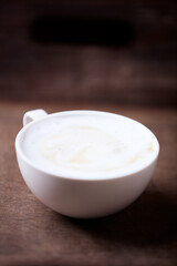 Cappuccino on dark wooden background. Soft focus. Close up.