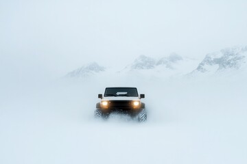 Off-road vehicle emerges through thick snow, showcasing resilien
