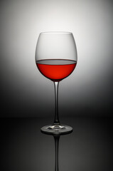 Elegant red wine glass capturing light in a minimalist setting showcasing its rich hue and fine craftsmanship