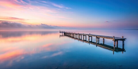 Fototapeta premium Serene Dawn A Wooden Pier Extends into the Still Waters of a Lake at Sunrise, Mirrored in the Calm Surface, Creating a Peaceful and Tranquil Atmosphere