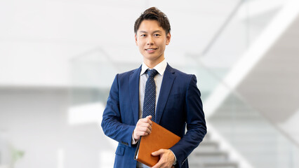 バインダーを持つ笑顔の男性ビジネスマン