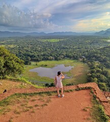 A woman takes in the breathtaking view from the top of Sigiriya Rock, Sri Lanka, overlooking lush landscapes