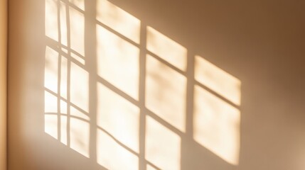 Soft sunlight creates intricate shadows on a beige wall, reflecting the patterns of window frames during early morning hours