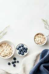 Fototapeta premium Breakfast preparation with oats and blueberries displayed on a light surface in a cozy setting