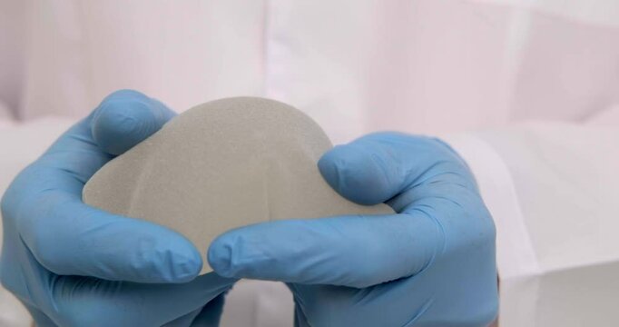 doctor holding breast enlargement implant in hands, plastic surgery concept, beauty enhancement, medical Mammoplasty and plastic surgery, mastopexy