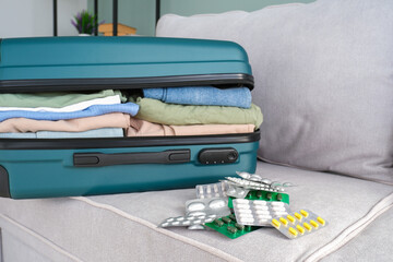 Clothes and pills in a travel bag. Concept of medication required in journey