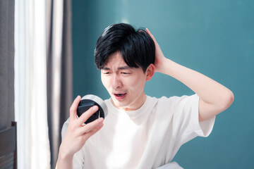 寝坊をして焦る若い男性