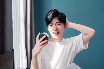 寝坊をして焦る若い男性