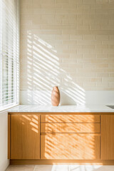 Elegant kitchen design with natural light casting shadows on wooden cabinetry