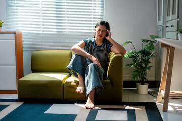 Obraz premium Young Woman Suffering From Headache While Relaxing on Sofa at Home