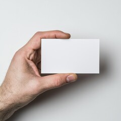 Fototapeta premium Hand holding blank business card against white background