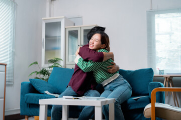 Obraz premium Happy couple hugging on sofa after choosing new house plan
