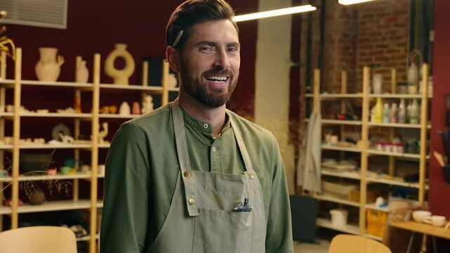 Crazy laughing shocked Caucasian man small business owner craftsman businessman potter crock male looking at camera laughing screaming emotion reaction shouting yell madness indoors pottery workshop