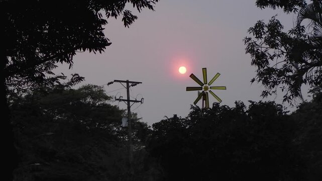 Backlit Sunset with Windmill and Light Pole