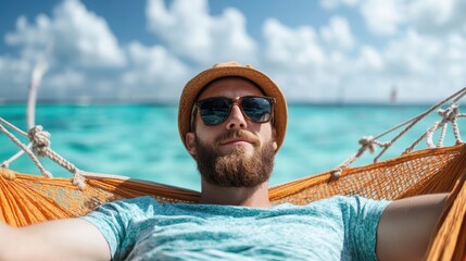 A man in a hammock enjoys the ocean view while wearing sunglasses and a straw hat, immersing himself in a tranquil seaside atmosphere under a bright blue sky.