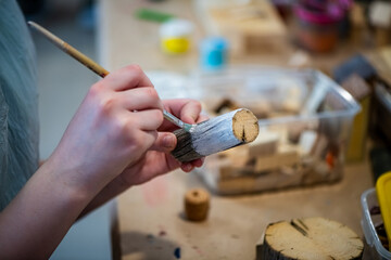 cute teen girl at a master class making a craft from wood, exhibition of crafts, crafts fair, education, master classes
