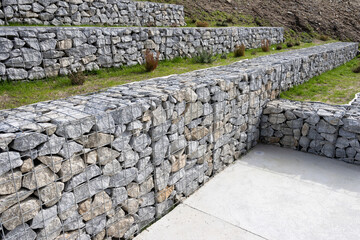Modern gabion walls made of granite stones and wire mesh, used for landscaping