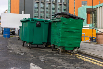 Row of Large Outdoor Commercial Green Recycling Waste Bins on City Asphalt Street