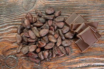 Broken dark chocolate and cocoa beans on the table