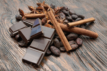 Broken dark chocolate and cocoa beans on the table