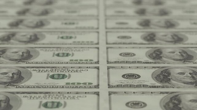 Close-up animation of printing 100 dollar notes, old style, arranged in neat rows.