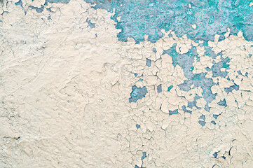 Peeling paint of the old rough concrete wall, peeling paint texture, peeling painted concrete wall, cracks of blue and beige paint on the stone wall