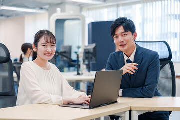 先輩社員から業務を教えてもらう新人の女性