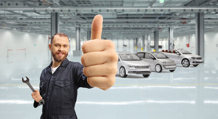 Mechanic with a wrench in his hand gesturing thumbs up