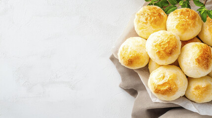 Freshly baked Brazilian cheese bread rolls on linen cloth, golden and fluffy