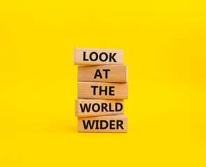 Look at the world wider symbol. Wooden blocks with words Look at the world wider. Beautiful yellow background. Business and Look at the world wider concept. Copy space.