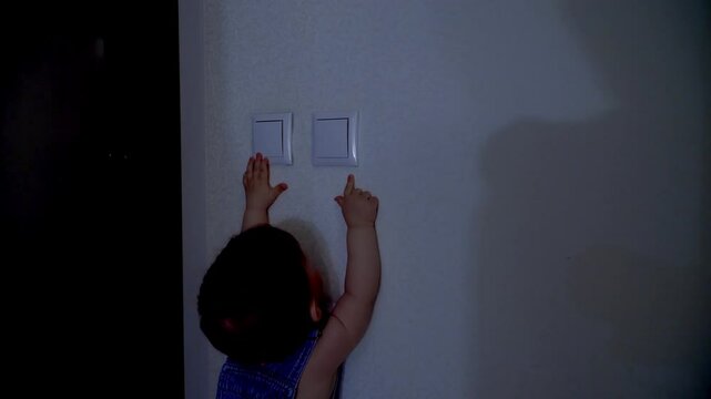 toddler child turned off the light in the apartment by pressing the switch