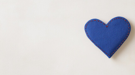 Obraz premium blue fabric heart with red stitching on light background evokes warmth and affection