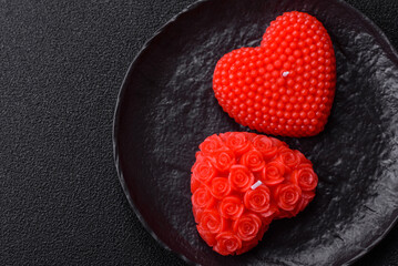 Red wax candle in the shape of a heart as decor for Valentine's Day