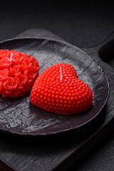 Red wax candle in the shape of a heart as decor for Valentine's Day