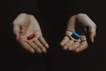 Choice Pills: Two hands, each offering a pill—one red, one blue—against a darkened background, inviting contemplation and evoking a pivotal decision.