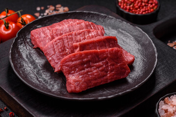 Raw beef tenderloin cut into slices with salt and spices